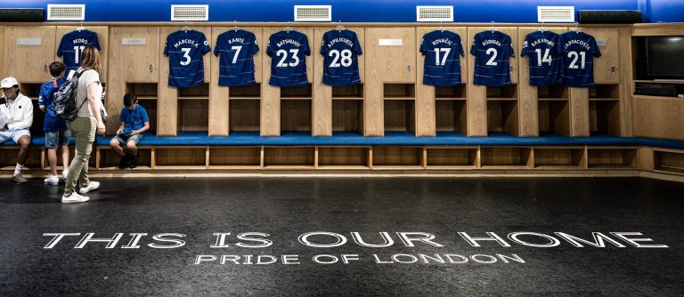 Locker room at Stamford Bridge featuring Chelsea FC jerseys and the Pride of London motto.